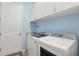 Functional laundry room with front load washer and dryer plus ample storage cabinets at 43406 Boardwalk Loop, Punta Gorda, FL 33982