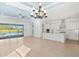 Spacious living area flows into kitchen, boasting white cabinets, an island, and seamless access to the outdoor pool area at 43406 Boardwalk Loop, Punta Gorda, FL 33982