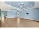 Expansive living room with tray ceiling, modern ceiling fan, tile flooring, and plenty of natural light at 43406 Boardwalk Loop, Punta Gorda, FL 33982
