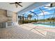 An outdoor kitchen, built-in grill, and patio seating next to the pool and lake view at 43406 Boardwalk Loop, Punta Gorda, FL 33982