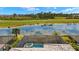 Backyard view featuring a screened-in pool overlooking a beautiful lake and manicured golf course at 43406 Boardwalk Loop, Punta Gorda, FL 33982
