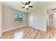Bright bedroom featuring wood-look floors and a ceiling fan at 4380 Maddock Cir, North Port, FL 34286