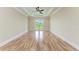 Spacious bedroom with wood floors, ceiling fan, tray ceiling with LED lighting and glass patio doors to the back yard at 4380 Maddock Cir, North Port, FL 34286