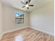 Sunlit bedroom boasts a window view and wood-look flooring at 4380 Maddock Cir, North Port, FL 34286