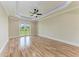 Bright bedroom with wood floors, ceiling fan, tray ceiling with LED lighting and glass patio doors to the back yard at 4380 Maddock Cir, North Port, FL 34286