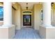 Elegant front entrance with stately columns, a dark wood door, and a 'Welcome' mat at 4380 Maddock Cir, North Port, FL 34286