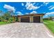 A spacious three-car garage with stylish brown doors complements the home's design at 4380 Maddock Cir, North Port, FL 34286