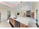 Open kitchen with stainless steel appliances, island, stone fireplace, and luxury flooring at 4380 Maddock Cir, North Port, FL 34286