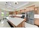 Spacious kitchen with an island, wooden cabinets, recessed lighting and stainless steel appliances at 4380 Maddock Cir, North Port, FL 34286
