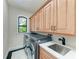 Well-equipped laundry room with sink and ample cabinet space at 4380 Maddock Cir, North Port, FL 34286