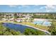 Scenic aerial view of community amenities, pool, tennis courts, lush landscaping, and a tranquil lake at 541 Wekiva River Ct # 94, Englewood, FL 34223