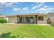The exterior backyard shows the screened in patio, green grass, and side window at 541 Wekiva River Ct # 94, Englewood, FL 34223