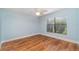 An unfurnished bedroom features wood floors and a sun-filled window with a white ceiling fan at 541 Wekiva River Ct # 94, Englewood, FL 34223