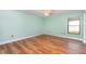 Empty bedroom with wood flooring and a window with blind, providing ample natural light at 541 Wekiva River Ct # 94, Englewood, FL 34223