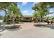 Community clubhouse with well-maintained landscaping, benches, and ample parking at 541 Wekiva River Ct # 94, Englewood, FL 34223