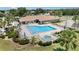 Aerial view of the community pool, featuring lounge chairs, umbrellas, and a hot tub at 541 Wekiva River Ct # 94, Englewood, FL 34223