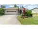 Charming single-story home with a well-manicured lawn, mature landscaping, and attached garage at 541 Wekiva River Ct # 94, Englewood, FL 34223