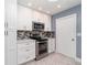 Kitchen featuring stainless appliances, modern tile backsplash, and plenty of storage at 541 Wekiva River Ct # 94, Englewood, FL 34223