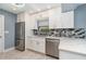 Beautiful kitchen featuring stainless steel appliances, white cabinetry, and modern countertops at 541 Wekiva River Ct # 94, Englewood, FL 34223