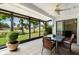 Enclosed lanai featuring tile flooring, ceiling fan, and views of the landscaped backyard at 541 Wekiva River Ct # 94, Englewood, FL 34223