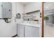 Functional laundry room equipped with washer, dryer, and shelving for storage at 541 Wekiva River Ct # 94, Englewood, FL 34223