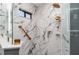 Shower room with elegant marble walls, glass door, and fixtures with brass finish at 541 Wekiva River Ct # 94, Englewood, FL 34223