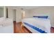 Bedroom featuring a queen bed with blue and white bedding and hardwood floors at 5725 Greenwood Ave # 2101, North Port, FL 34287