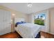 Bright bedroom features a plush bed, wood floors, and a large window with a scenic view at 5725 Greenwood Ave # 2101, North Port, FL 34287