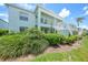 Exterior view of condo building featuring mature landscaping and staircase at 5725 Greenwood Ave # 2101, North Port, FL 34287