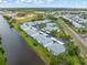 Aerial view showcasing a condo community along a canal with a community pool and covered parking at 5725 Greenwood Ave # 8203, North Port, FL 34287