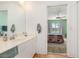 Bathroom featuring a single vanity and mirror, open to a bedroom with a colorful patchwork quilt at 5725 Greenwood Ave # 8203, North Port, FL 34287