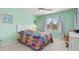 Bright bedroom featuring a colorful patchwork quilt, a ceiling fan, and a window with natural light at 5725 Greenwood Ave # 8203, North Port, FL 34287