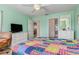 Bedroom featuring a colorful patchwork quilt, a ceiling fan, and access to the ensuite bathroom and closet at 5725 Greenwood Ave # 8203, North Port, FL 34287
