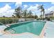 A sparkling community pool in a gated area with clear blue water, safety equipment and furniture at 5725 Greenwood Ave # 8203, North Port, FL 34287