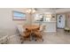 Cozy dining area with a chandelier, wall art, and seating for four around a wooden table, next to kitchen and front door at 5725 Greenwood Ave # 8203, North Port, FL 34287