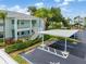 Exterior view of a two-story condo with parking and mature, lush landscaping at 5725 Greenwood Ave # 8203, North Port, FL 34287
