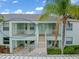 Exterior view of a two-story condo unit with a private balcony and mature palm trees at 5725 Greenwood Ave # 8203, North Port, FL 34287
