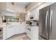 Open kitchen featuring stainless steel refrigerator, white cabinets, and a view into the living spaces at 5725 Greenwood Ave # 8203, North Port, FL 34287