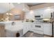 Well-lit kitchen with white cabinets, modern appliances, and a view into the dining area at 5725 Greenwood Ave # 8203, North Port, FL 34287
