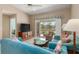 Inviting living room with blue sofas, entertainment center, and access to a screened-in porch overlooking a serene water view at 5725 Greenwood Ave # 8203, North Port, FL 34287