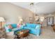 Living area showcasing blue sofas, a rattan coffee table, and partial views into the dining area and front door at 5725 Greenwood Ave # 8203, North Port, FL 34287