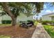Outdoor picnic area has a grill, table, and mature tree for shaded relaxation at 5725 Greenwood Ave # 8203, North Port, FL 34287