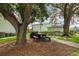 Community picnic area features mature shade trees, a picnic table and charcoal grill at 5725 Greenwood Ave # 8203, North Port, FL 34287