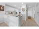 Kitchen view featuring white cabinets, breakfast bar, and tile flooring at 5762 Sabal Trace Dr # 203, North Port, FL 34287