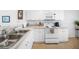 Well-lit kitchen featuring white appliances and plenty of counter space at 5762 Sabal Trace Dr # 203, North Port, FL 34287
