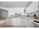 Well-lit kitchen featuring a double sink, ample counter space, and white cabinetry at 5762 Sabal Trace Dr # 203, North Port, FL 34287