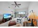 Living room with comfy furniture, TV, ceiling fan, and sliding glass doors to screened balcony at 5762 Sabal Trace Dr # 203, North Port, FL 34287
