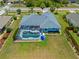 Aerial view of a blue home with a screened pool and spacious backyard at 7183 Spinnaker Blvd, Englewood, FL 34224