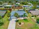 Charming single-story home features a screened-in pool, well-manicured lawn, and mature palm trees at 7183 Spinnaker Blvd, Englewood, FL 34224