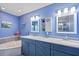 Bright bathroom with double vanity and blue cabinetry at 7183 Spinnaker Blvd, Englewood, FL 34224